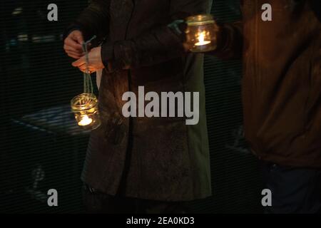 London, UK. 6th February, 2021. Candlelit vigil in remembrence of the lost trees at Euston Square, London as part of the Stop HS2 protest February 6th 2021. Close up of candles being carried in jars Credit: Denise Laura Baker/Alamy Live News Stock Photo