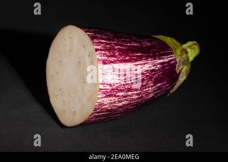 sliced striped eggplant on black background Stock Photo