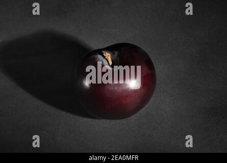deep red burgundy plum on black background Stock Photo