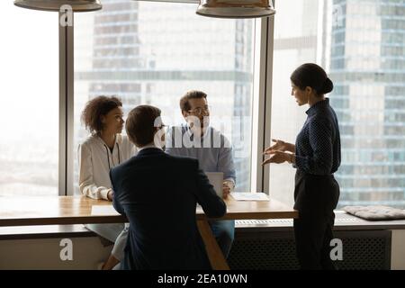 Confident indian female coach provide training to multiethnic corporate staff Stock Photo