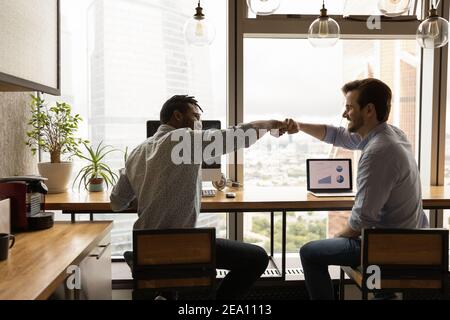 Two workers international team members share success help one another Stock Photo