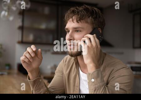 Inspired young man explain idea to business partner by phone Stock Photo