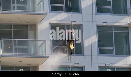 A man cleaning windows on a high rise building Stock Photo
