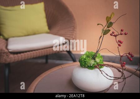 Minimalism style interior design of the terrace in the villa. Rattan weaved furniture with glass on the table and comfortable pillows in chair. Stock Photo