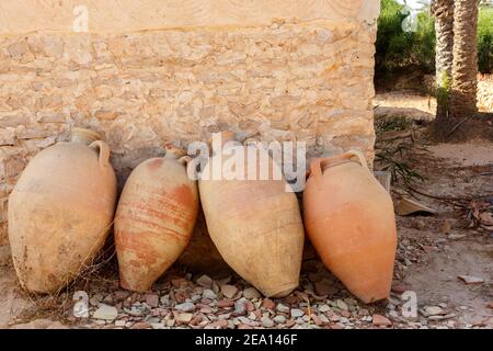 Old earthenware jars against the wall in the shade Stock Photo