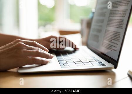 Close up of woman typing on laptop keyboard Stock Photo