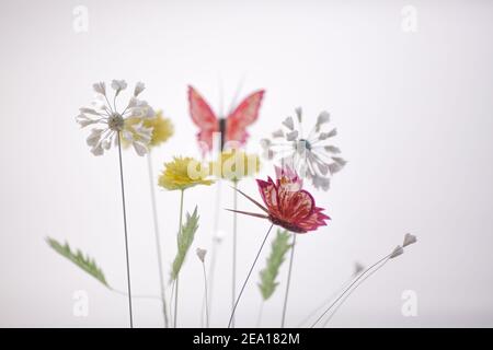 Spring composition with paper flowers and butterfly on white background with light Stock Photo