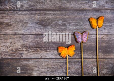 Hand painted gingerbread butterflies on wooden background. Top view. Sweet dessert as a gift for women's day on 8 March. Flat lay. Copy space Stock Photo