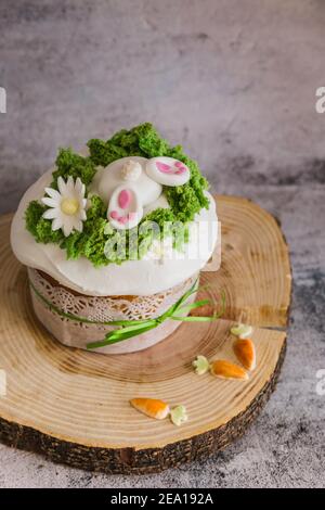 Easter Cakes decorated with a hare dives into a hole on wooden plate - Traditional Kulich, Paska Easter Bread. Traditional Easter spring Stock Photo