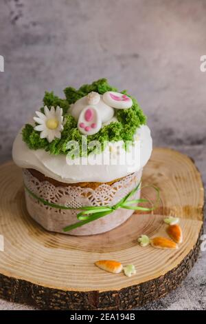 Easter Cakes decorated with a hare dives into a hole on wooden plate - Traditional Kulich, Paska Easter Bread. Traditional Easter spring Stock Photo