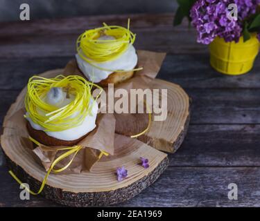 Easter Cakes decorated with yellow nest and eggs, lilac on background - Traditional Kulich, Paska Easter Bread. Traditional Easter spring Stock Photo