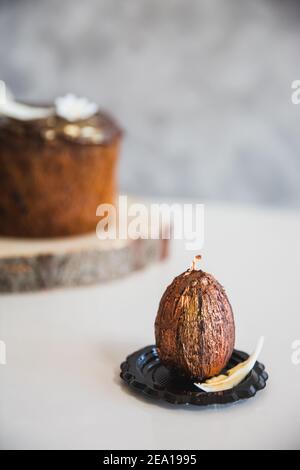 Handmade chocolate with gold easter egg with easter cake on background. Close-up, copy spase Stock Photo