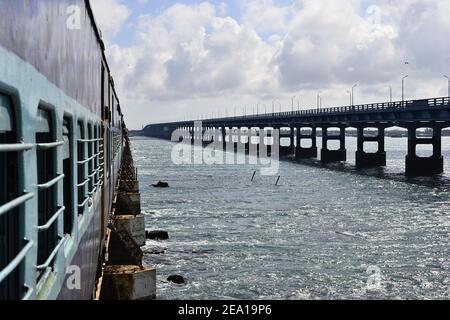 Indian railway train on the railroad bridge over the sea called Pamban Bridge that connects Rameswaram on Pamban Island with mainland. Long road bridg Stock Photo