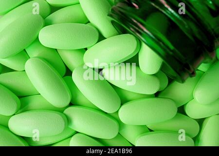 Top view of Lime green tablets poured from dark color glass bottle Stock Photo