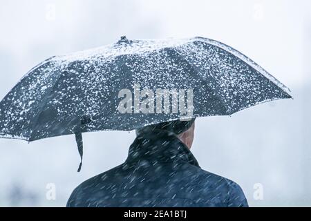 Wimbledon London Uk 7 February 21 A Pedestrian Shelters Underneath An Umbrella During Shower Shower On Wimbledon Common As Storm Darcy Hits The Uk This Morning With Freezing Temperatures The Met Office Has