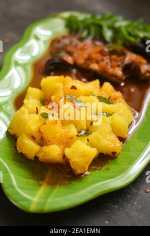 Top view tapioca with spicy hot Kerala fish curry Indian food. pearl spot fish curry red chili, curry leaf. Asian cuisine. Delicious spicy Bengali Stock Photo