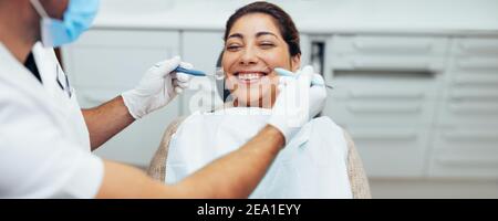 Teeth checkup at dentist's office. Smiling woman in dental clinic with doctor. Stock Photo