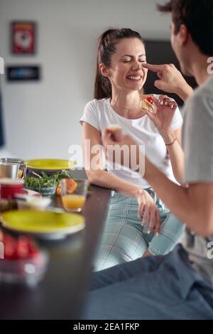 A young couple having fun while having breakfast in a cheerful atmosphere at home. Couple, love, breakfast, together Stock Photo