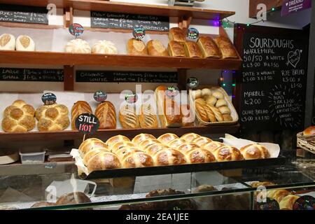 Baker shop with fresh loves and hot cross buns on display Stock Photo