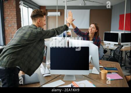 IT specialists high-five each other in office Stock Photo