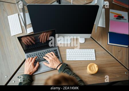 IT specialist works on laptop in office, top view Stock Photo