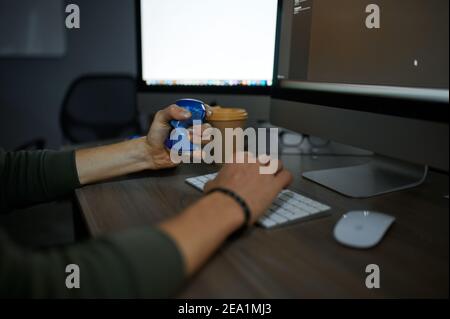Male hacker eats at monitor in dark office Stock Photo