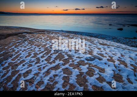 Beautiful winter sunset and snow patterns on rock at Larkollen by the coastline of the Oslofjord, Moss kommune, Østfold, Norway. Stock Photo