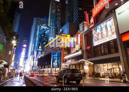 NEW YORK, USA - SEPTEMBER 20, 2013: night street broadway in new york . Yellow taxi, many people and advertising outdoor. Big black jeep in the foregr Stock Photo