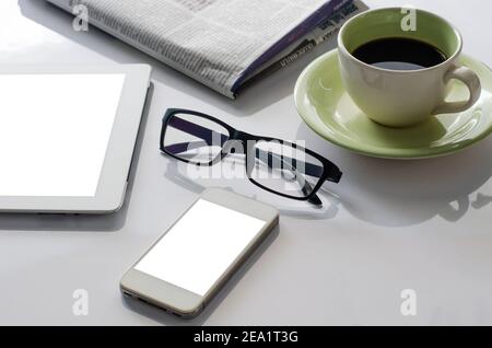 Glasses on the desk with smartphone ,Newspaper and coffee cup. Stock Photo