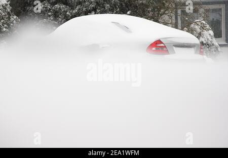 Bielefeld, Germany. 07th Feb, 2021. A snow-covered car is parked on a snow-covered road. Credit: Friso Gentsch/dpa/Alamy Live News Stock Photo