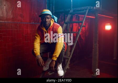 Stylish rapper poses on stairs in grunge studio Stock Photo - Alamy