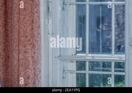window with red curtain in old house Stock Photo