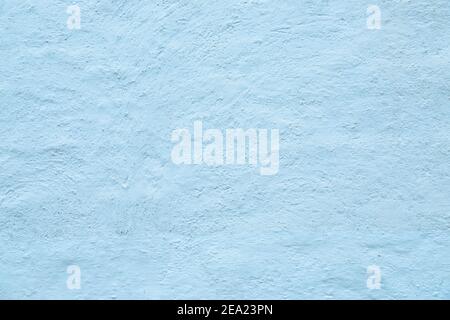 Texture of white stone whitewashed and plastered old wall. Image is tinted in blue light. Stock Photo