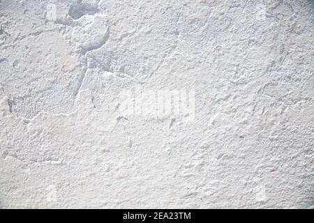 Close-up texture of white stone  old wall. Wall covered with lime. The wall of house on island  Santorini in  Greece. Stock Photo