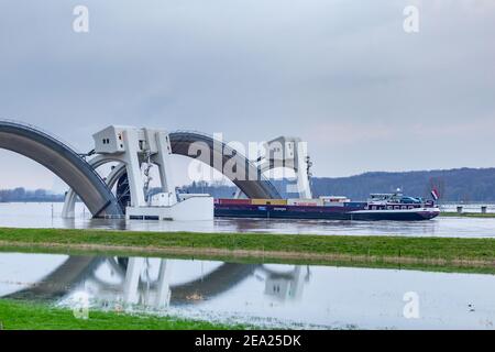 Driel, The Netherlands - February 5, 2021: Weir Driel in the river Rhine with ship passing through the open bows because of high water Stock Photo