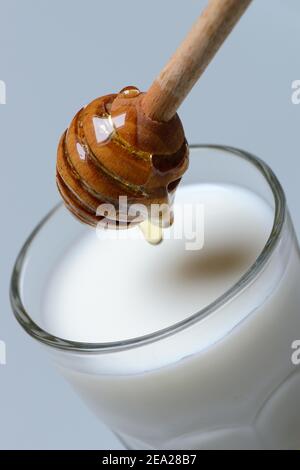 Honey milk, glass of milk with honey, honey spoon Stock Photo