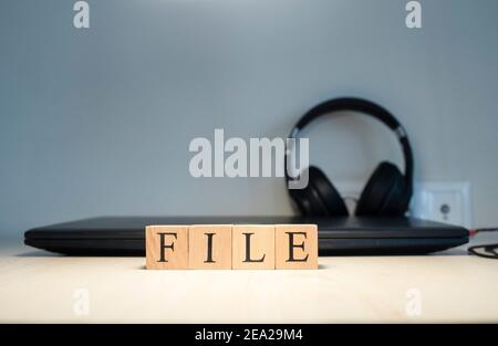 Word File. Computer and headphones concept on the background. Studio Stock Photo