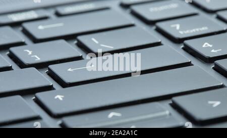 Gray laptop keyboard macro close-up. Selective focus on enter buttons. Stock Photo