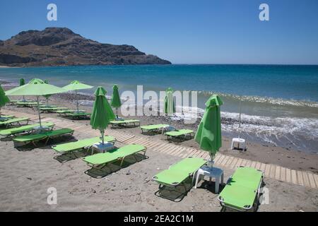 Empty beach with sunbeds in Greece on the island of Crete in quarantine. The concept of the collapse of tourism due to coronavirus Stock Photo