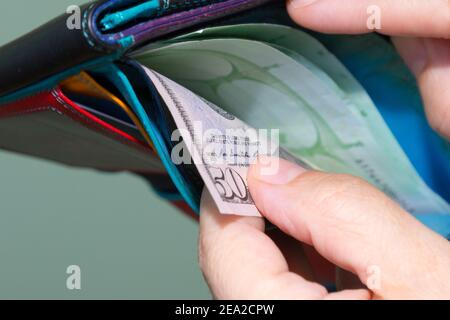 Close up of hands pulling  banknotes 50 dollar out of wallet Stock Photo