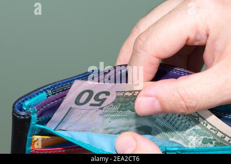 The hands pulling  banknotes 50 dollar out of wallet. Concept payments. Close up view. Stock Photo
