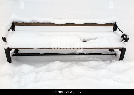 A bench in park covered in snow photo: Bo Arrhed Stock Photo