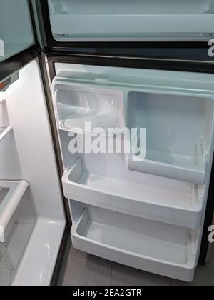 empty, modern refrigerator with opened doors. Inside of a clean fridge with plastic shelves Stock Photo