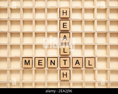 Mental Health crossword made with wooden blocks. Concept about mental illness, depression or child's mental well-being. Stock Photo