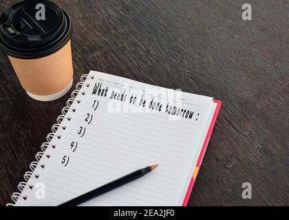 text on notepad with background of cup of coffee and a pen Stock Photo