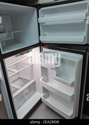 empty, modern refrigerator and freezer with opened doors. Inside of a clean fridge with plastic shelves Stock Photo