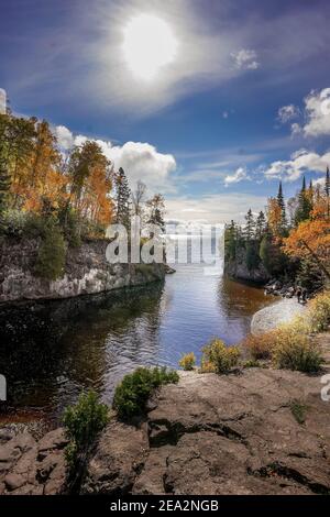 Sun shining over Baptism River where it meets Lake Superior at Tettegouche State Park, Minnesota Stock Photo