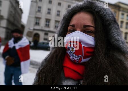 A protester wears a face mask with the historical white-red-white flag of Belarus during a protest in solidarity with Belarus political prisoners at Krakow's Unesco Listed Main Square. Stock Photo