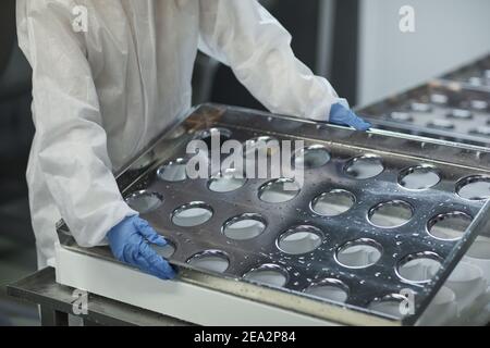 Cropped shot of unrecognizable worker holding cheese forms at clean food production factory, copy space Stock Photo