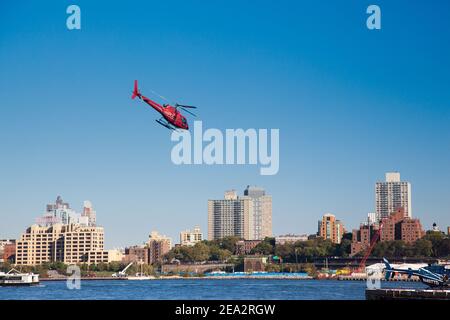 Helicopter is under Brooklyn. Red helicopter flies against the background of Brooklyn in the city of New York, USA. NEW YORK CITY - USA: OCTOBER 15 20 Stock Photo